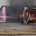 Protesters set fire to bus as unrest continues after knife attack