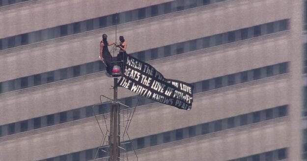 2 people climb to top of NYC’s Empire State Building, fly banner