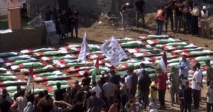 Mourners hold a mass funeral for 112 recovered bodies in Gaza
